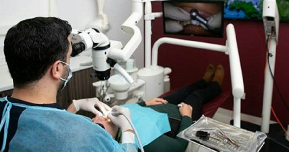 Medic stomatolog lucrând la microscopul dentar
